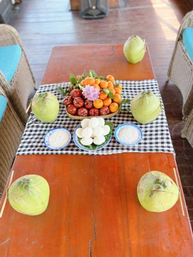 een tafel met een bord groenten en fruit erop bij Hide Away Bungalows in Ben Tre City in Ben Tre
