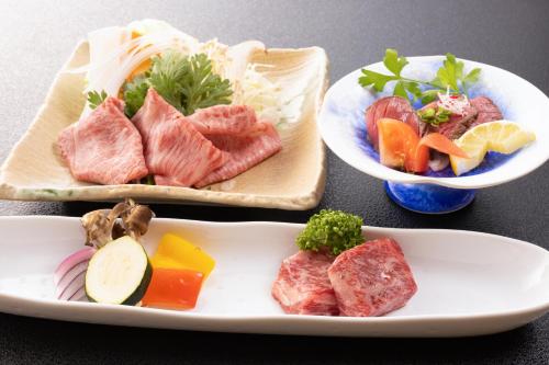 two plates of food with meat and vegetables on a table at Fulsato in Tsuchihatakozan