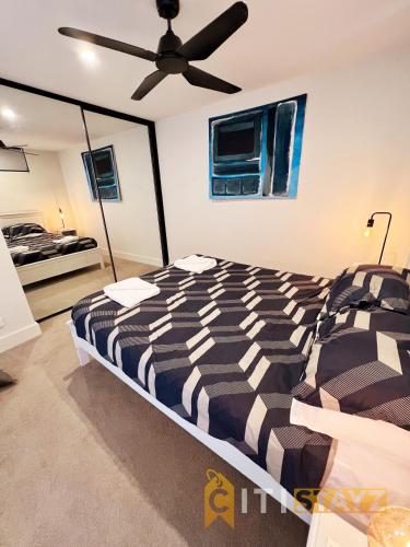 een slaapkamer met een bed en een plafondventilator bij Stylish, Modern, Cute as a Button - Braddon CBD in Canberra