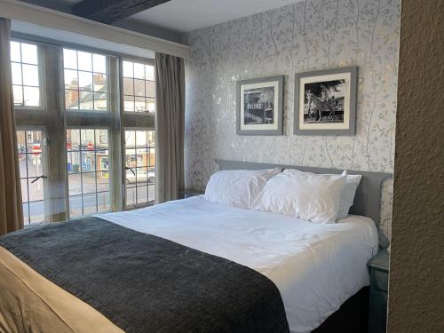 a bedroom with a bed with white sheets and a window at Cromwell Lodge Hotel by Greene King Inns in Banbury