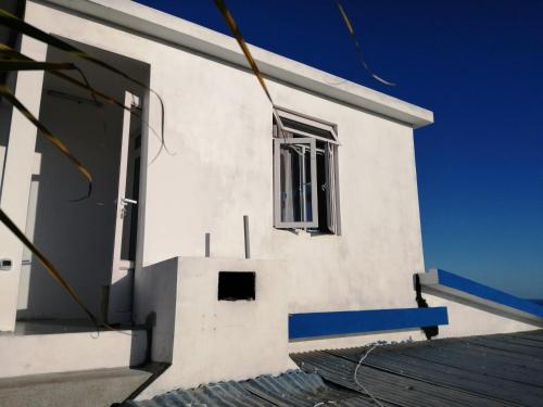 a white building with a window on the side at Ô Bercail du Sud chez Jeannette in Rodrigues Island