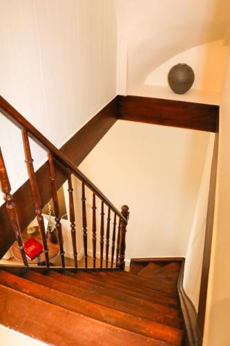 a stairwell with a wooden staircase with a vase on it at La Porte Rouge - The Red Door in Oudenaarde