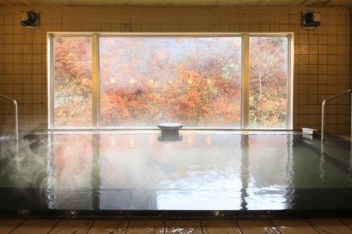a room with a large window and a pool of water at Fulsato in Tsuchihatakozan