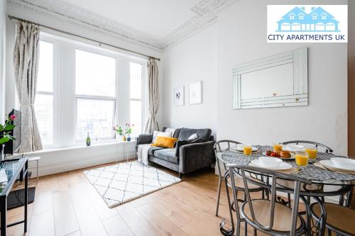 a living room with a table and a couch at Charming 1 Bed Apt in Kensington - Free London Tour Included By City Apartments UK Short Lets Serviced Accommodation in London