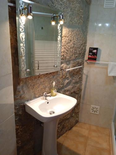 a bathroom with a sink and a mirror at Casa da Massada in Belmonte