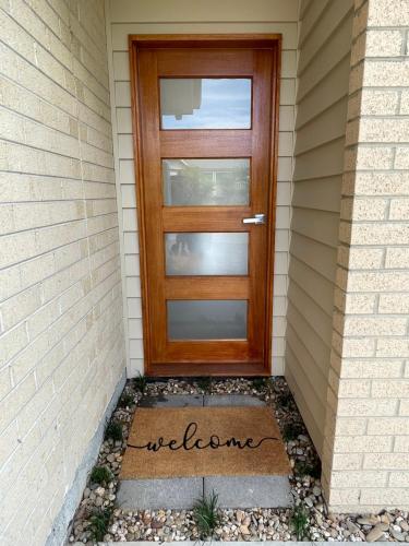 a door with the word welcome written in front of a house at Private guesthouse - Minutes from the beach! in Mornington