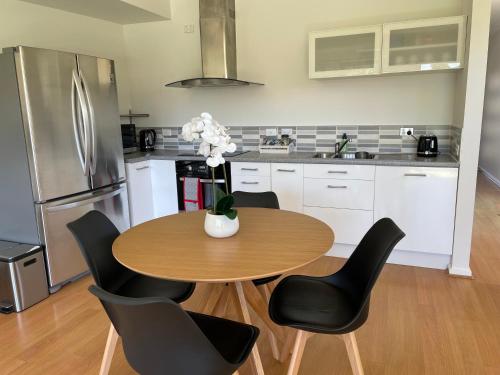 uma cozinha com uma mesa com cadeiras e um frigorífico em Private guesthouse - Minutes from the beach! em Mornington