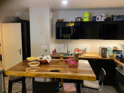 a kitchen with a wooden table with bowls on it at Super chambre avec salle de bain in Courcouronnes