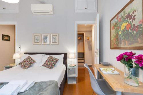 a bedroom with a bed and a table with flowers on it at Rome as you feel - Grotta Pinta apartments in Rome