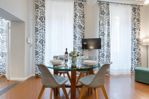 a dining room with a glass table and chairs at Rome as you feel - Grotta Pinta apartments in Rome