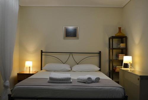 1 dormitorio con 1 cama con 2 toallas en Kalamata beach maizonette ground floor and semi-basement with yard, en Kalamata