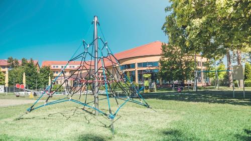 a playground equipment in the grass in front of a building at Wellness Hotel Patince in Patince