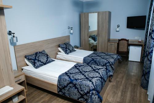 a hotel room with two beds and a tv at Nurtau in Pavlodar