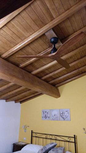a ceiling fan in a bedroom with wooden ceilings at B&B Il Grifo in Bomarzo