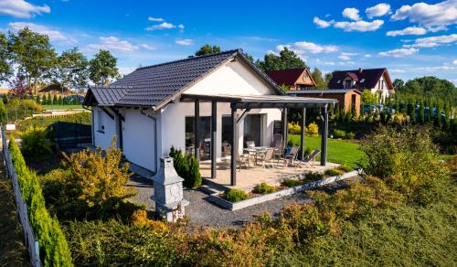 a small white house with a gazebo at Przystań Łagówek - domki letniskowe in Łagów