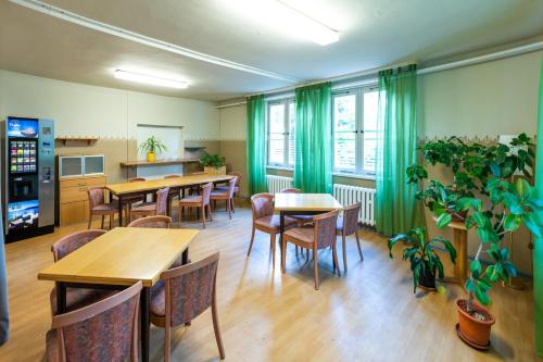 a restaurant with tables and chairs and green curtains at Pension Schwalbenweg in Schönefeld