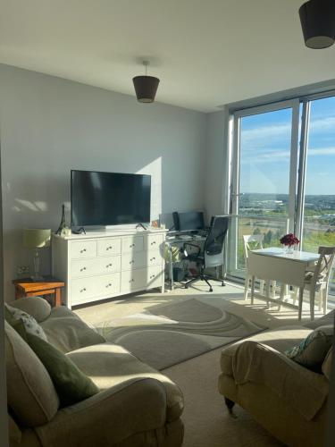 a living room with a couch and a tv and a table at Apartment 7 in Milton Keynes
