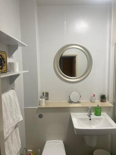 a white bathroom with a sink and a mirror at Apartment 7 in Milton Keynes