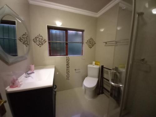 a bathroom with a toilet and a sink and a shower at 110 Bay View in Brenton-on-Sea