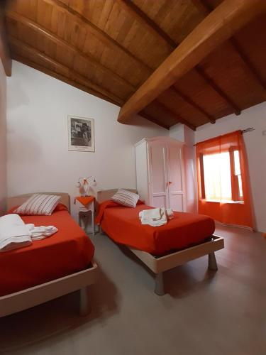 una camera da letto con due letti e una finestra di B&B Il Grifo a Bomarzo