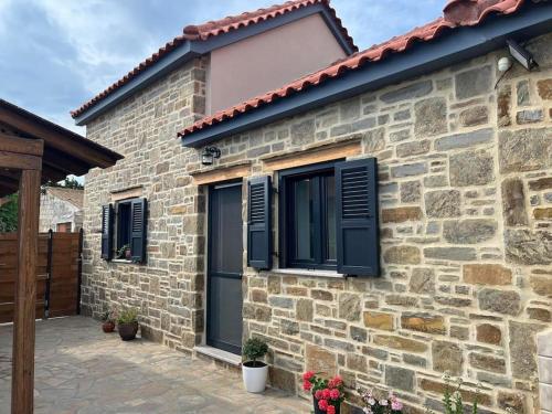 a brick house with black shutters on it at Almyra in Propoúlion