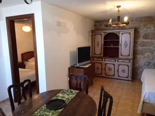 a living room with a table and a television at Casa da Massada in Belmonte