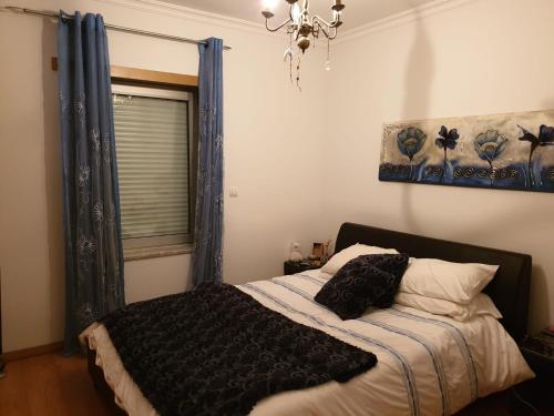 a bedroom with a bed and a window and a chandelier at Splendor Residence Apartment in Portimão