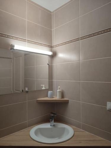 une salle de bain avec un lavabo et un miroir dans l'établissement Gîte des remparts réservation par téléphone laissez vos coordonnées, à La Côte-Saint-André