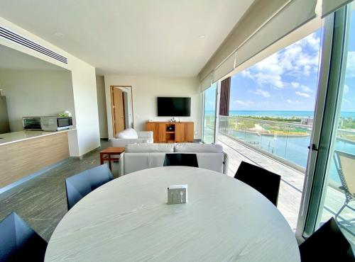 a room with a table and chairs and a large window at Rooftop pool- family apartment- ocean view -close in Cancún