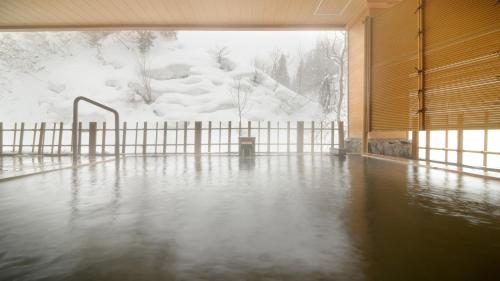 a room with a flooded floor with snow on the ground at Fulsato in Tsuchihatakozan
