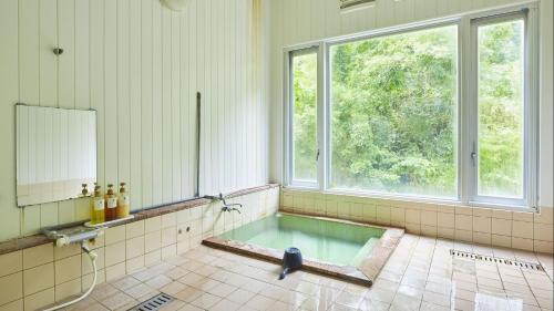 a large bathroom with a tub with a window at Fulsato in Tsuchihatakozan