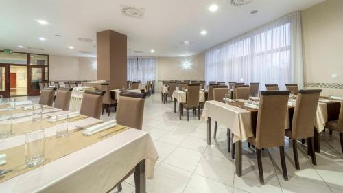 a restaurant with tables and chairs in a room at Wellness Hotel Patince in Patince