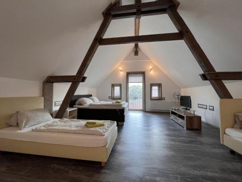 a attic bedroom with two beds and a tv at Dill Apartments Gadenstedt in Ilsede