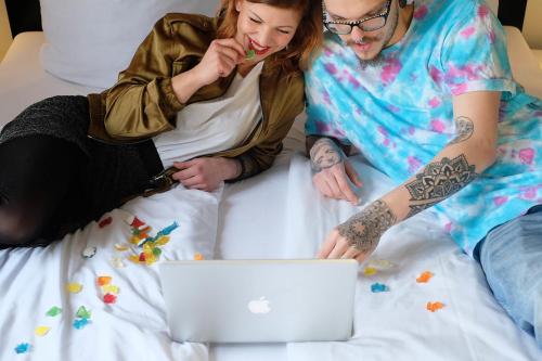 two people laying on a bed with a laptop at Pfefferbett Hostel in Berlin