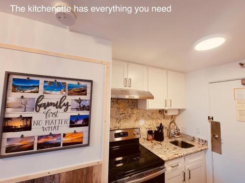 a kitchen with a picture hanging on the wall at Waikiki High-rise sea view free parking in Honolulu