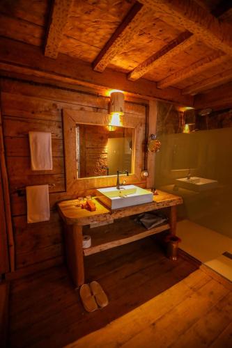 a bathroom with a sink and a mirror in a cabin at Hotel Xaluca Spa Aguelmame Sidi Ali in Aguelman