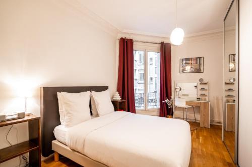 a bedroom with a large white bed and a desk at Veeve - Vivid, Vivace in Paris