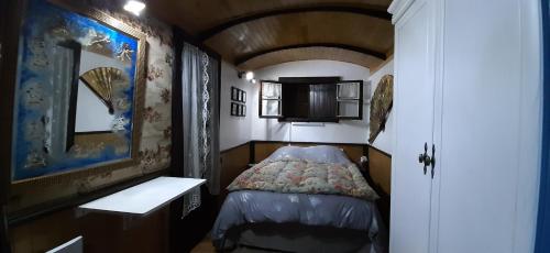 a small room with a bed and a sink at Gite Roulottes de l' Alchimiste in Montjoie-en-Couserans