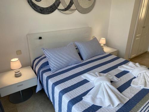 a blue and white striped bed in a bedroom at Seaside Miramar in Puerto de Mogán