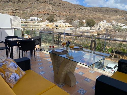 a balcony with a table and a view of a city at Seaside Miramar in Puerto de Mogán
