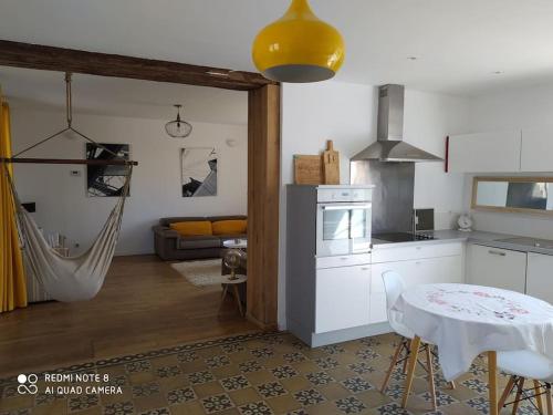 eine Küche mit einem Tisch und einem Esszimmer in der Unterkunft Maison de la Vaux in Germonville