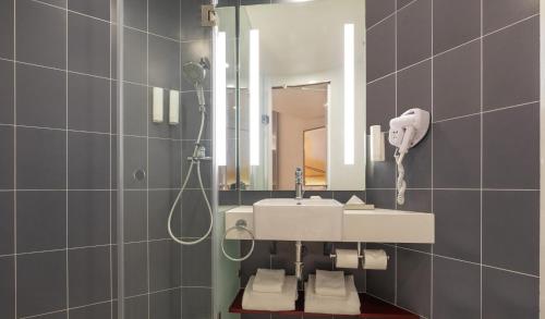 ibis Thane - An Accor Brand في ثين: حمام مع حوض ومرآة