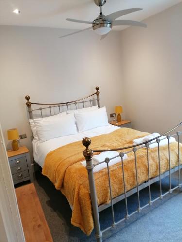 1 dormitorio con 1 cama y ventilador de techo en Halt Cottage, en Bridgnorth