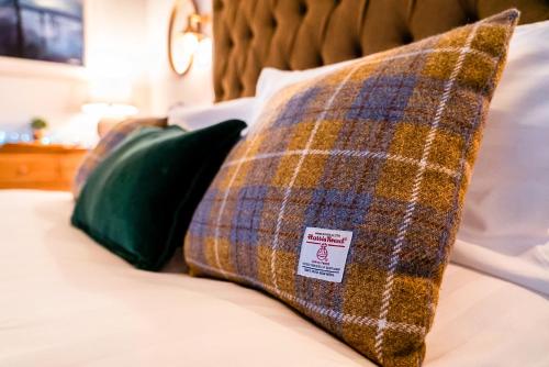 uma almofada xadrez e uma almofada verde numa cama em The Shorehouse em Broadford