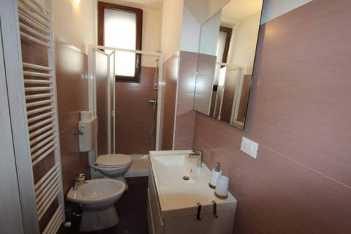 W łazience znajduje się umywalka, toaleta i lustro. w obiekcie Villa Teresa w mieście Leuca