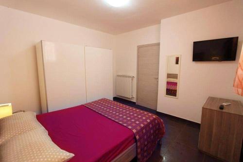 1 dormitorio con 1 cama y TV en la pared en Villa Teresa, en Leuca