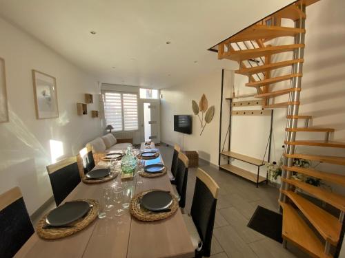 a dining room with a table and chairs and a staircase at Gite comme chez soi Ducey les Chèris in Ducey