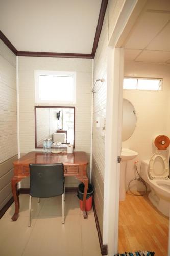 a small room with a desk and a toilet at Baan Sabuy Jung in Aranyaprathet