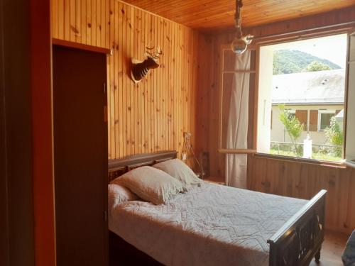 1 dormitorio con 1 cama en una habitación con ventana en la maison blanche, en Ustou