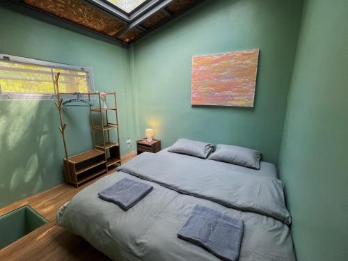 1 dormitorio con 1 cama en una pared verde en Greenspace Living, en Ban Tha Phae